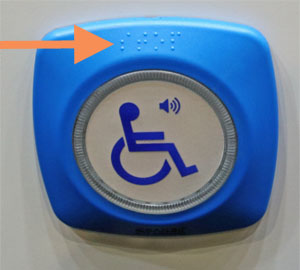 Taster au&szlig;en an einem Bus, die taktile Beschriftung in Brailleschrift steht f&uuml;r STOP.  Foto: Bernd Kittendorf, 2026